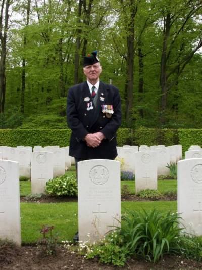 Richard Massey standing at the Headstone of Private W.E. Maddock