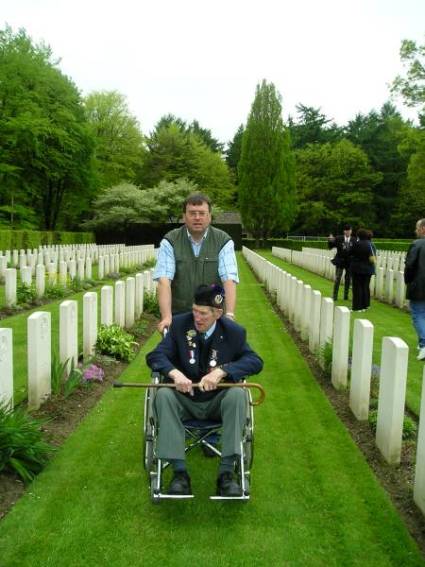 Peter van der Krabben ecorting George Sands along the rows of headstones, Reichswald Forest war cemetery, Germany